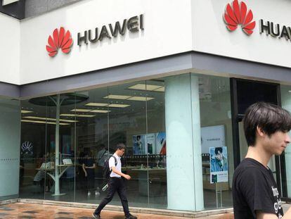 Varias personas pasan junto a una tienda de Huawei en Shenzhen, en China.
