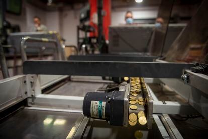 Miles de monedas pasan por una de las cintas para separar las de diferente valor, en una de las plantas de las empresas de transporte en efectivo en Vicálvaro, el pasado 25 de enero.