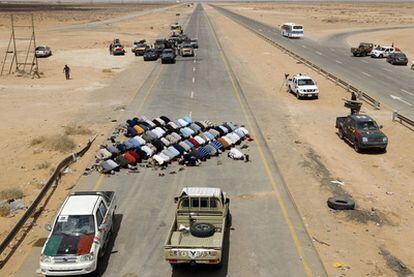 Combatientes rebeldes rezan en un puesto de control cerca de Abu Grein, unos 160 kilómetros al oeste de Sirte.