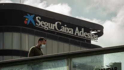 Un transeúnte pasa ante la sede de SegurCaixa Adeslas en Barcelona, el pasado abril.