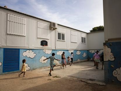 Los alumnos de la escuela del Bosc de Rubí juegan en la pequeña pista de baloncesto que hay entre los barracones.