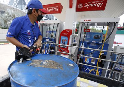 A gas station attendant fills a barrel of fuel last week in Bangkok, Thailand.