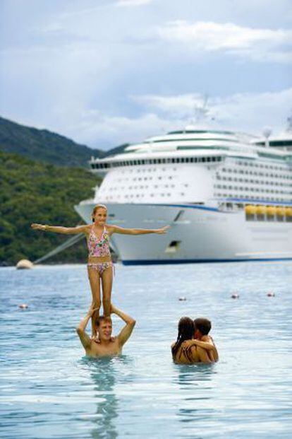 Una familia se baña en el Caribe con un crucero al fondo.