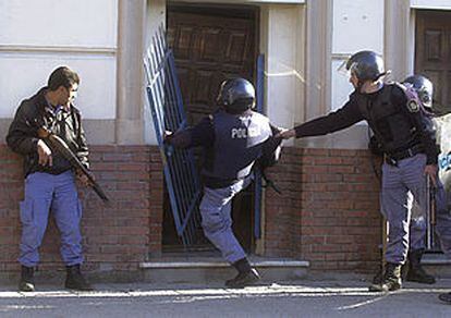 Policías argentinos echan abajo la puerta de la sede de un partido de izquierda donde se habían refugiado varios manifestantes el pasado 26 de junio.