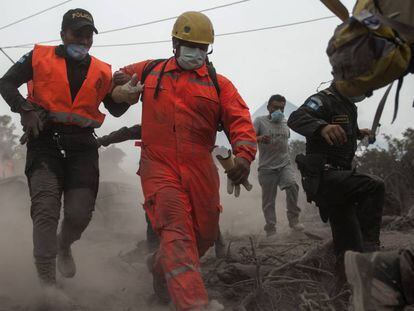 Bomberos y policías evacuan una zona de rescate en Escuintla, Guatemala.