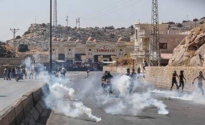 Policías turcos lanzan botes de gas lacrimógeno para dispesar a los sirios que se habían congregado frente a la puerta fronteriza para intentar buscar refugio en suelo turco el pasado fin de semana.