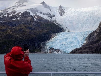 Un turista fotografía con su móvil la lengua de color azul berilo del glaciar Italia, en el canal Beagle (Chile).