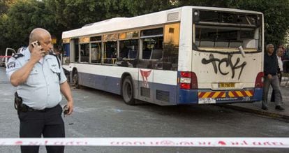 Un polic&iacute;a junto al autob&uacute;s donde se produjo la explosi&oacute;n.