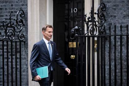 El ministro británico de Economía, Jeremy Hunt, salía este jueves del número 10 de Downing Street, sede de la oficina del primer ministro, en dirección al Parlamento para presentar su plan fiscal.