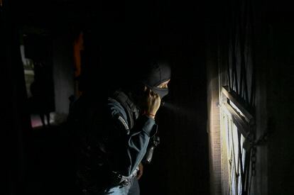 A police officer uses his flashlight during an investigative operation in San José, in August 2023.