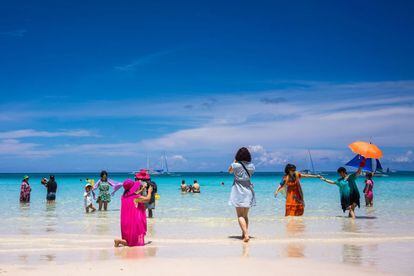 White Beach, la playa que aparece en la foto, tomada el pasado mes de julio, está en Borácay (Filipinas), un islote de coral de siete kilómetros de largo por uno de ancho en el archipiélago de las Bisayas, a unos 350 kilómetros al sur de Manila. Los arrecifes coralinos de las Bisayas son conocidos por su variedad de especies marinas; además, playas como Bulabog, White Beach, Lapuz, Punta Bunga, Puka Shell o Banyugán, con arena tan blanca que parece de algodón (borac, en tagalo, de ahí su nombre), han colocado a esta pequeña isla en la lista de los parajes costeros más deseados. Descubierta por los mochileros en la década de los ochenta, se ha convertido en uno de los principales destinos turísticos de Filipinas, con decenas de resorts de lujo, restaurantes, discotecas y una trepidante vida nocturna. A Borácay se accede en ferri (el trayecto dura unos diez minutos) desde el vecino puerto de Caticlán, en la isla de Panay, donde se encuentra el aeropuerto.