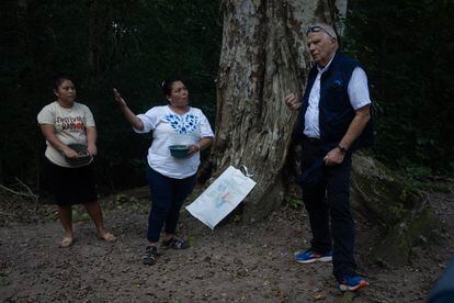 Josep Borrell conversa con mujeres del Petén que le muestran como recogen los frutos del ramón, un árbol común en la selva maya.