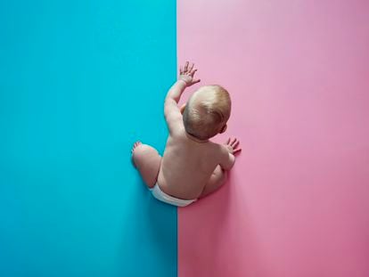Un bebé gatea sobre un suelo rosa y azul. A través de algo tan asexual y neutro como los colores, la sociedad puede encasillar a las personas según su género.