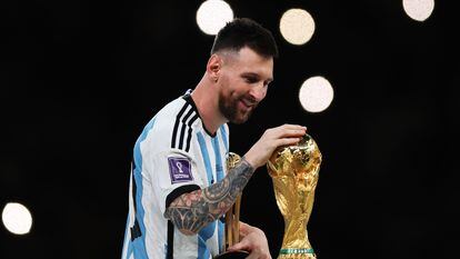 Lionel Messi toca la copa del mundo después de que la selección Argentina venciera por penaltis a Francia en la final del mundial de Qatar 2022.