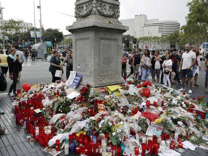 Barceloneses y turistas hacen un alto en el Memorial con flores a las v&iacute;ctimas del atentado terrorista, situado al comienzo de las Ramblas de Barcelona.