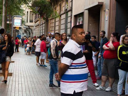 Decenas de personas hacen cola ante una comisar&iacute;a de Barcelona para conseguir cita para el DNI, en una imagen de julio de 2016.