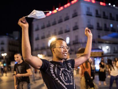 Un chico celebra el fin del uso obligatorio de la mascarilla en espacios abiertos en la Puerta del Sol, en Madrid.