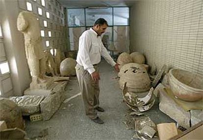 Un iraquí muestra objetos históricos destrozados en el Museo Arqueológico de Bagdad.