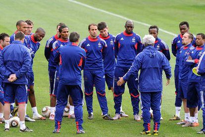 Los jugadores franceses escuchan a Raymond Domenech (de espaldas con el pelo blanco) en el entrenamiento de ayer en Knysna.