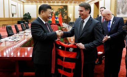 El presidente chino, Xi Jinping, recibe como regalo de parte de Jair Bolsonaro, presidente de Brasil, una chaqueta con el escudo y colores del equipo de fútbol Flamengo, de Río de Janeiro, en China, en octubre de 2019.
