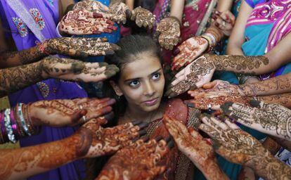 Un grupo de escolares muestran sus manos decoradas con henna en la ciudad india de Ahmedabad.
