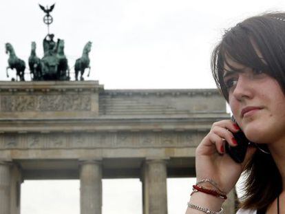 Una mujer habla por tel&eacute;fono frente a la Puerta de Brandemburgo, en Berl&iacute;n.
