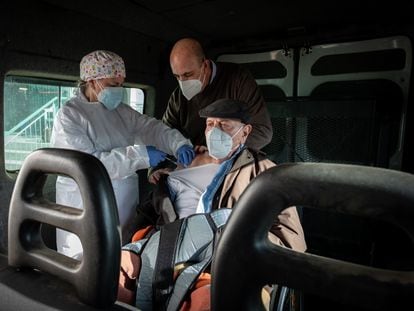 Lorenzo García, de 93 años, recibe la primera dosis de la vacuna acompañado de su hijo Manolo, dentro de una furgoneta adaptada para silla de ruedas.