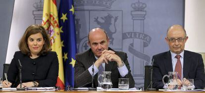 La vicepresidenta del Gobierno, Soraya Sáenz de Santamaría, junto a los ministros de Economía, Luis de Guindos; y de Hacienda, Cristóbal Montoro.