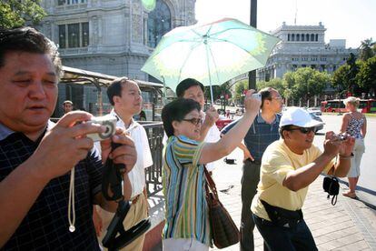 Turistas chinos hacen fotografías en la Plaza de la Cibeles de Madrid.