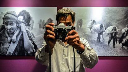 El fotógrafo José Rodríguez posa frente a imágenes de desplazados.