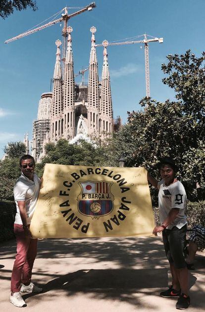 Hiroki Nakano (izquierda), presidente de la  Penya FC Barcelona Japan, posa con una bandera delante de la Sagrada Familia.