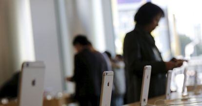 Una mujer consulta un iPhone 6 en una tienda de Apple en Pekín.