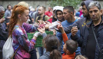 Voluntarios distribuyen comida a refugiados en Berl&iacute;n.