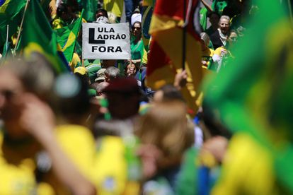 Miles de seguidores del presidente Jair Bolsonaro se manifestaron este miércoles para pedir abiertamente que los militares lideren una “intervención federal” contra el futuro Gobierno de Luiz Inácio Lula da Silva. En la imagen, una mujer entre una multitud sostiene un cartel con la frase "Lula, ladrón, fuera", en Porto Alegre, el 2 de noviembre de 2022. 