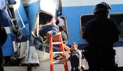 Equipos de rescate sacan a un pasajero del interior del tren, en la estación de Once