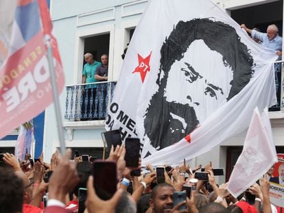 El candidato presidencial Lula junto a una enorme bandera con su imagen de una ficha policial de los ochenta, este domingo en un mitin en Río de Janeiro.