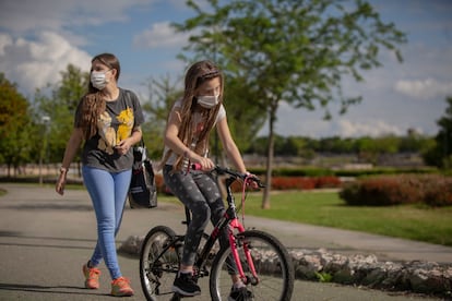 Una mujer y su hija pasean por un parque de Sevilla, este martes.