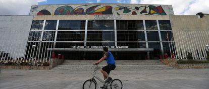 Un ciclista pasa por delante del Palacio de Congresos.