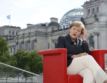 La canciller alemana, Angela Merkel, sonríe durante la entrevista que concedió a las cadenas alemans ARD y ZDF frente a la sede del Parlamento alemán