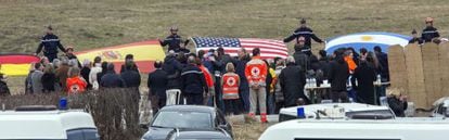 Miembros de los equipos de rescate despliegan banderas de las nacionalidades de las víctimas ante sus familiares, este jueves en Le Vernet.