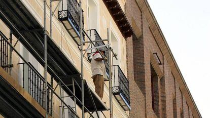 Un hombre trabaja en la rehabilitación de una fachada en Madrid, en una imagen de archivo.
