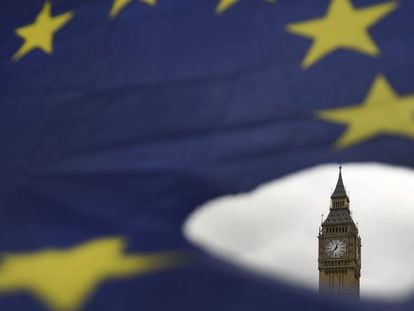El Big Ben asoma por un roto en una bandera de la Uni&oacute;n Europea en Londres.