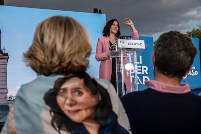 Esperanza Aguirre escucha a Isabel Díaz Ayuso con un pañuelo con su imagen.