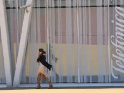 Una mujer pasea junto a la sede de Telef&oacute;nica en Barcelona.