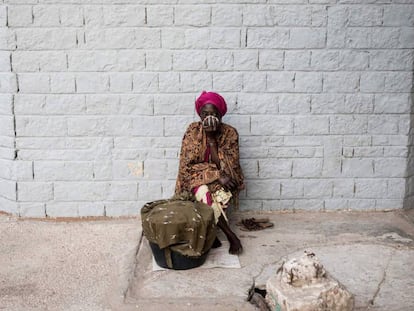 Una mujer senegalesa se cubre la nariz y la boca mientras los trabajadores municipales de Dakar desinfectan una clínica como medida preventiva contra la propagación del coronavirus. 