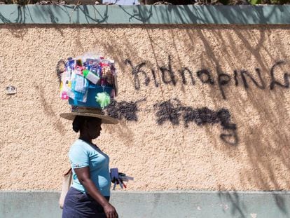 Una mujer pasa junto a un grafiti en el que se lee “Abajo los secuestros” el 16 de febrero en Puerto Príncipe (Haití).