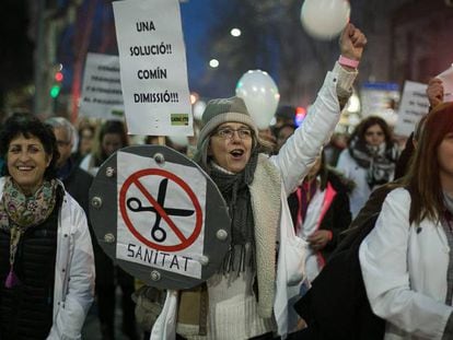 Una manifestante sostiene un cartel pidiendo la dimisi&oacute;n del consejero de salud, Toni Comin.