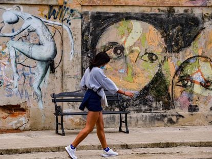 Una estudiante pasea delante de un grafitti en La Habana este 17 de noviembre.