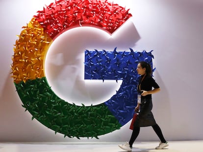 Una mujer pasa frente a un logotipo de Google en una feria de importación celebrada en Shanghái.