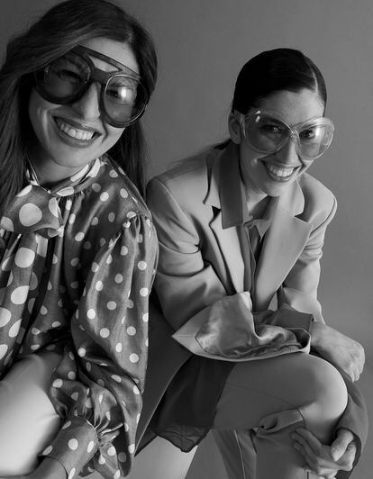 Patricia Espejo (izquierda) lleva lazada de seda y pantalón blanco de Max Mara y gafas de Tom Ford. Pilar de Francisco viste traje gris con puños abiertos y camisa roja de Duarte y gafas de Tom Ford.